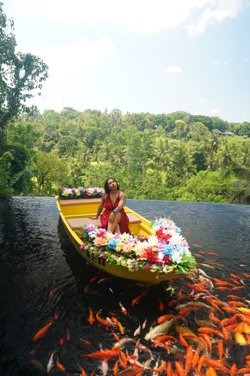 A Plus traveler surrounded by flowers and koi in Bali